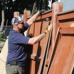  BOND employee Joe Santos goes to work repairing fence railings at 354 Cross St. in Malden for Housing Families Inc.  